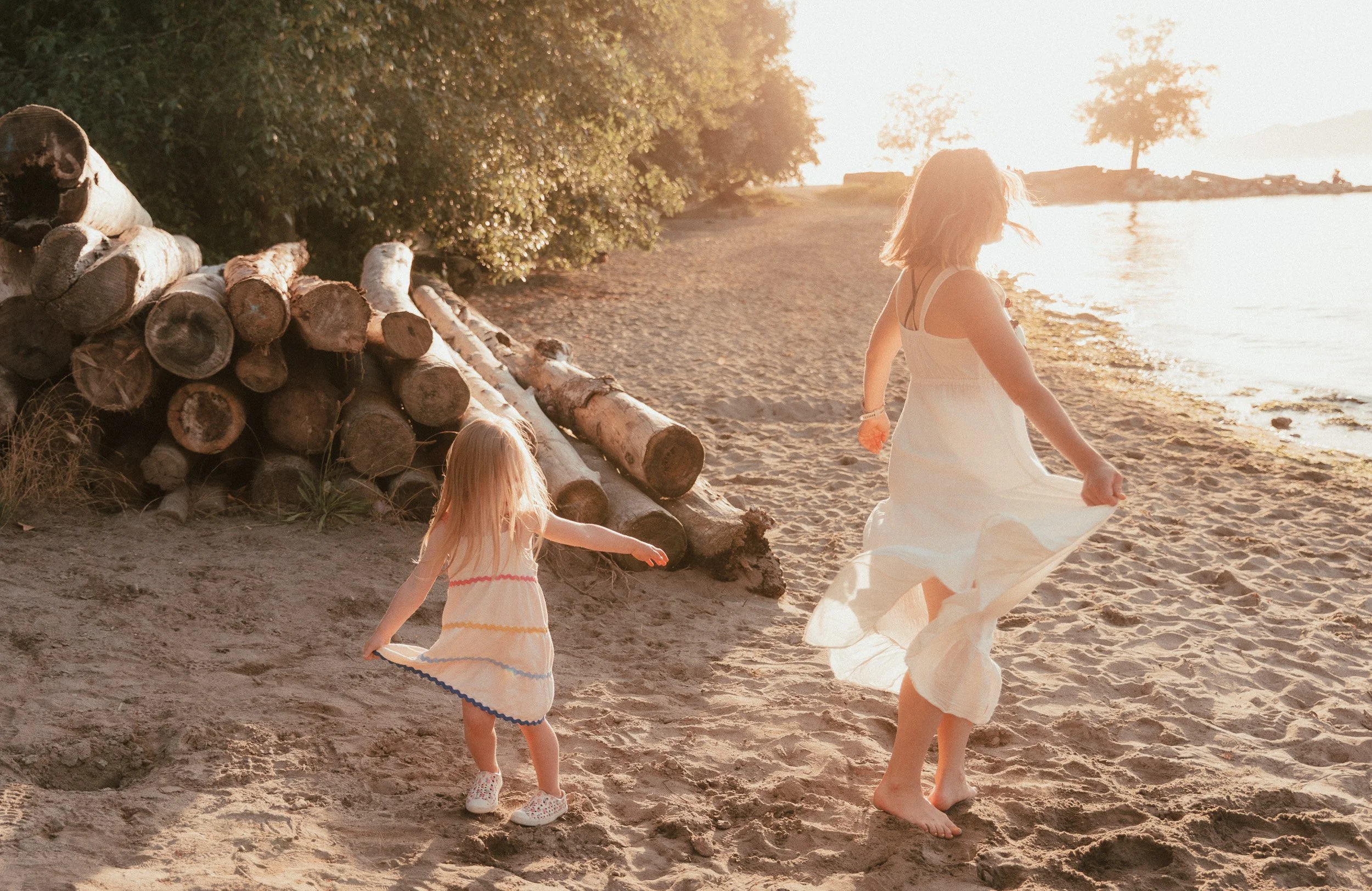 Mum and daughter dancing on the sandy beach of Vancouver