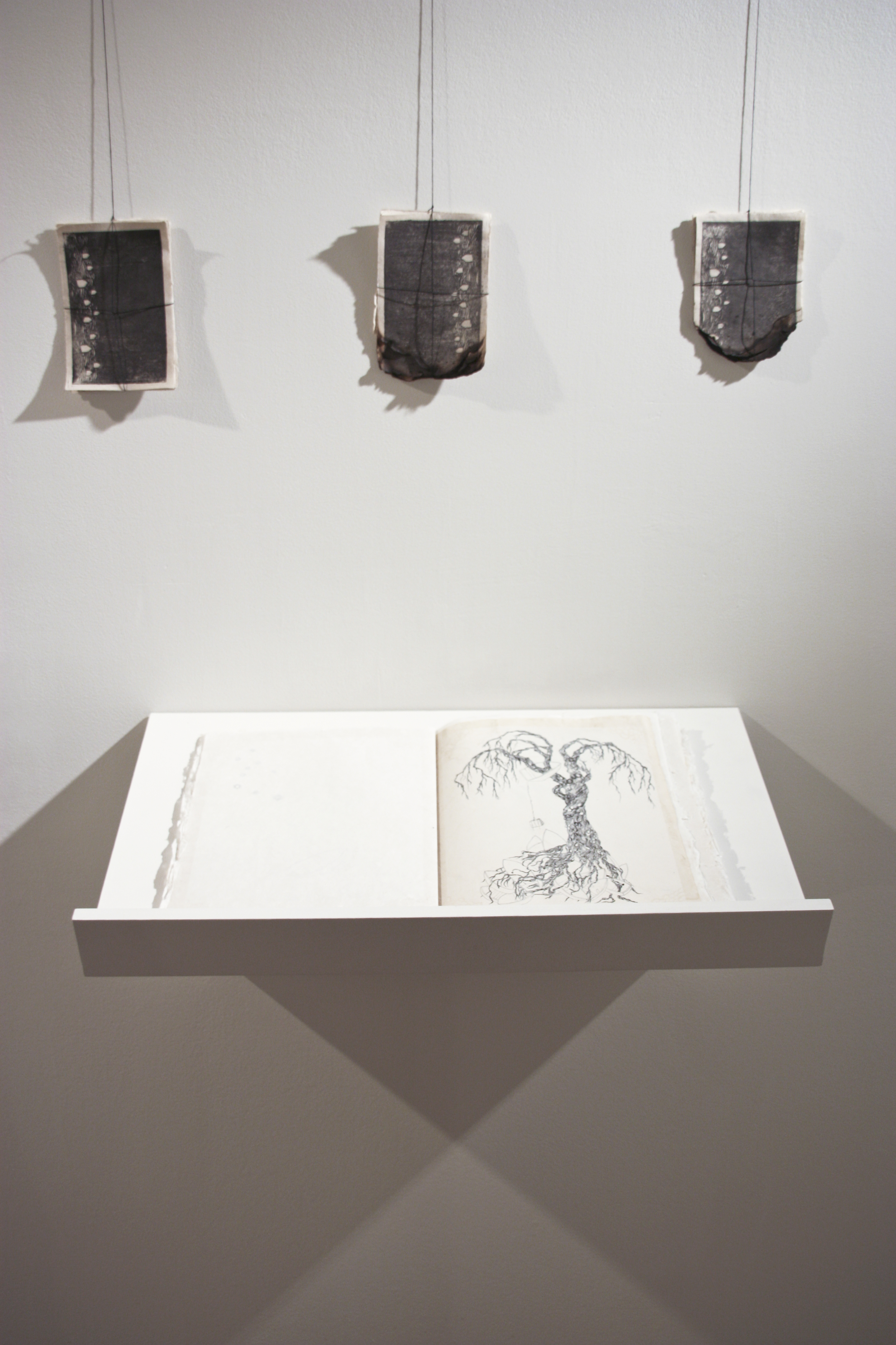    farthest  , 2013 original artist’s book with hand-printed backgrounds and burnt groupings of single-color mokuhanga prints; exhibition view  handmade paper (abaca, kozo), sumi, ink, hand-dyed linen thread book: 12 x 9” closed  Irving Arts Center 