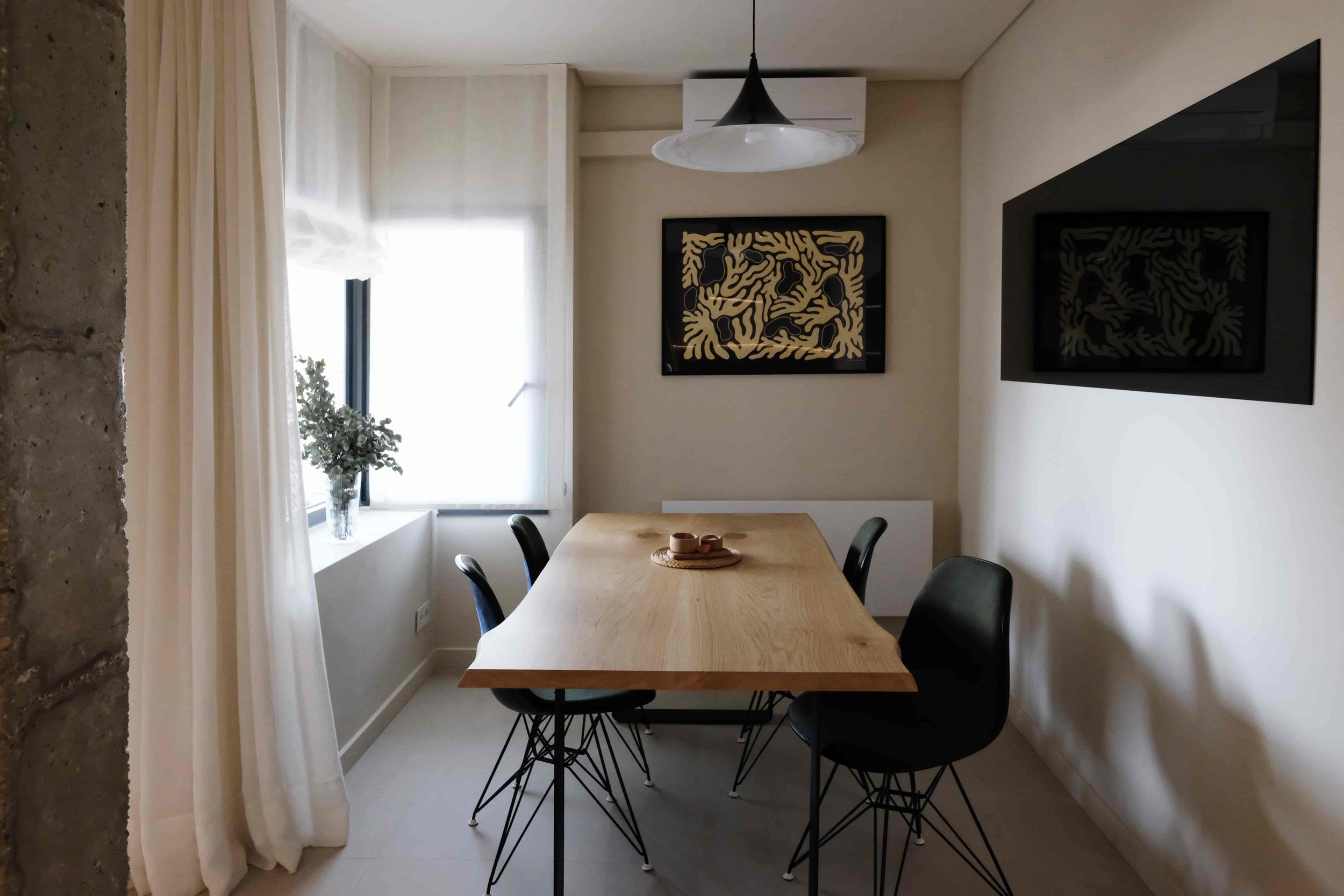 Casa Costa Barcelona healthy interiors retrofit living room with live edge table, vitra chairs by charles eames, smoked glass mirror