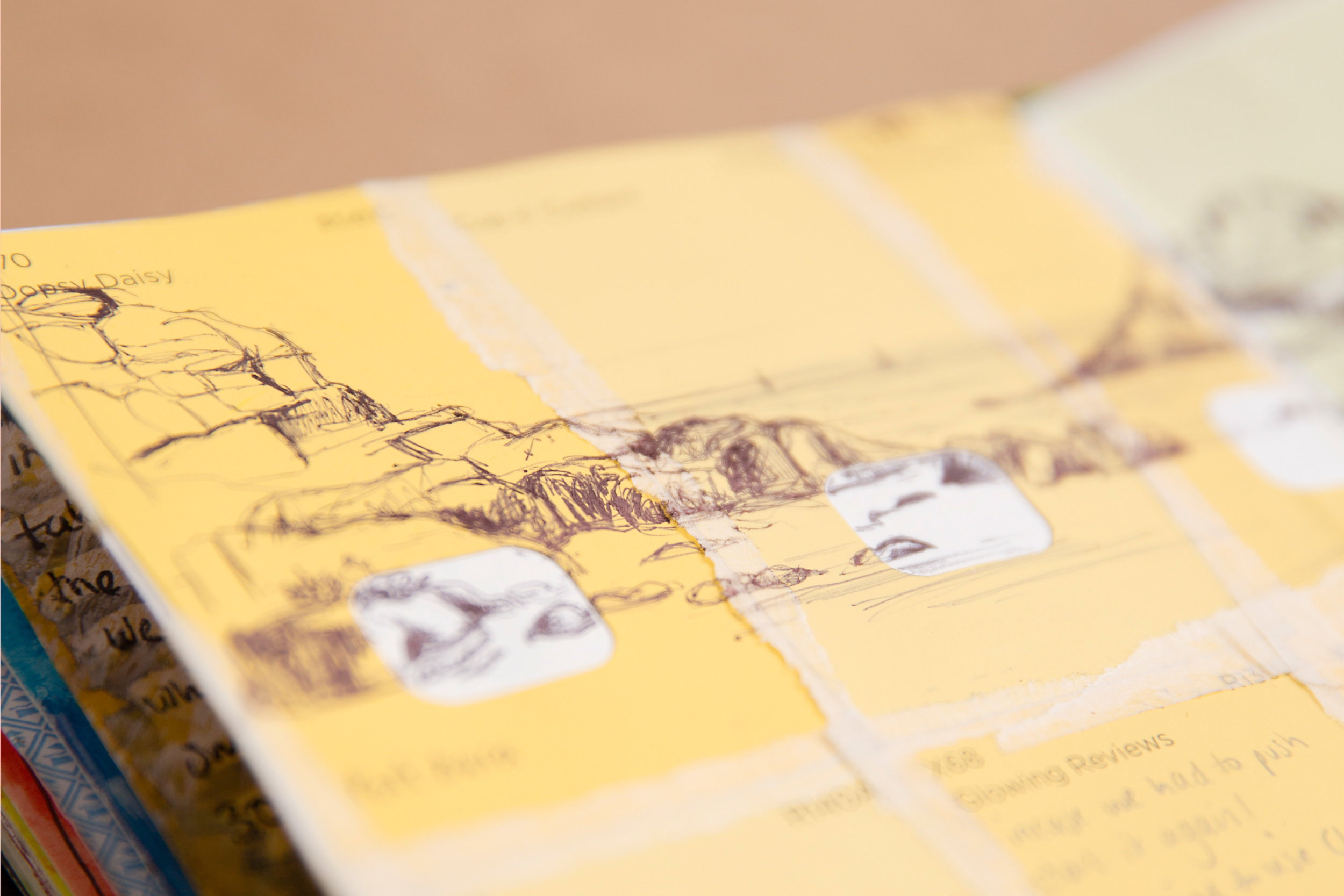 Detail of yellow art page in art book of drawn landscape sea scape beach on yellow paint swatches mixed media art collage work drawing