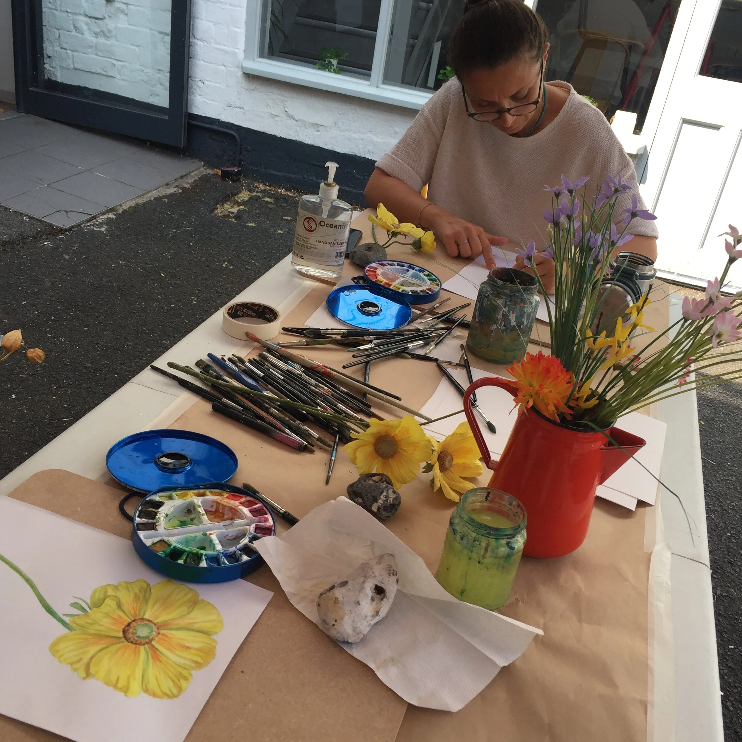Out door watercolour class with painted flowers dried stems display and paper on art table in Woodingsyard