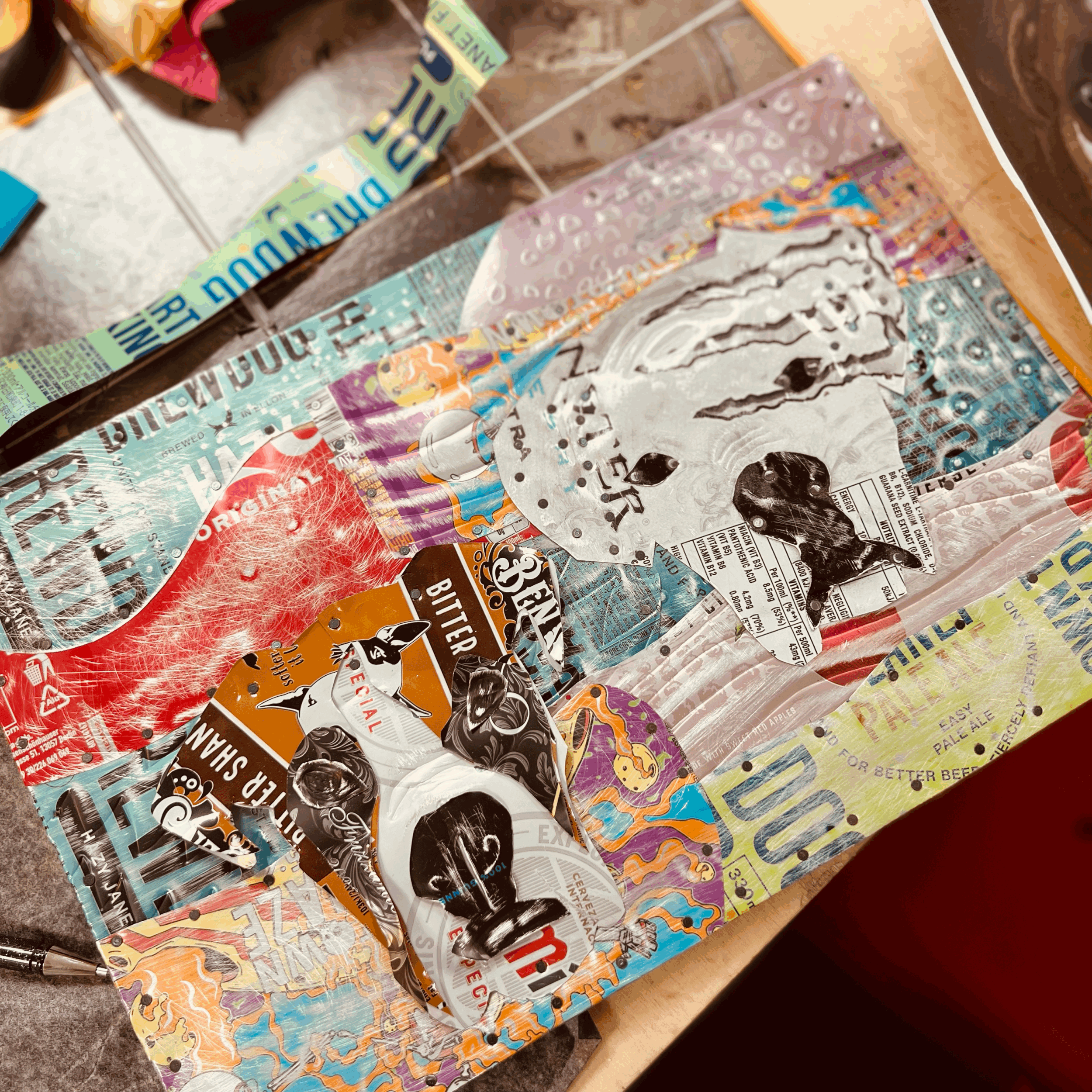 Picture of two dogs boxer dog heads made form colourful drinks can soda can metal nailed onto a board