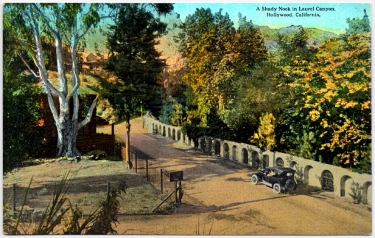 A postcard showing Laurel Canyon Boulevard at Lookout Mountain Road in the 1920's. The property on the right was developed by Harry Houdini, and the one on the left was owned by Tom Mix. His log cabin, which was the site of many rock star gatherings in the 1970's, can be seen just past the tree on the left.