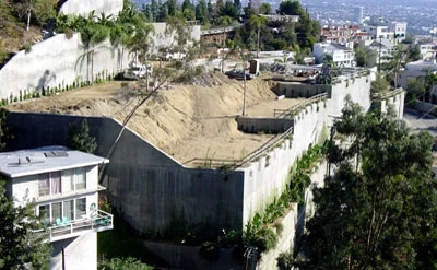 An example of inappropriate development with massive grading and huge retaining walls. Notice how the home on the left is dwarfed by this project.