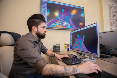 Using the same CAD program he learned at GIA, Chalmers designs a two-toned solitaire engagement ring. Customers can view tweaks instantly on the wall monitor behind him.