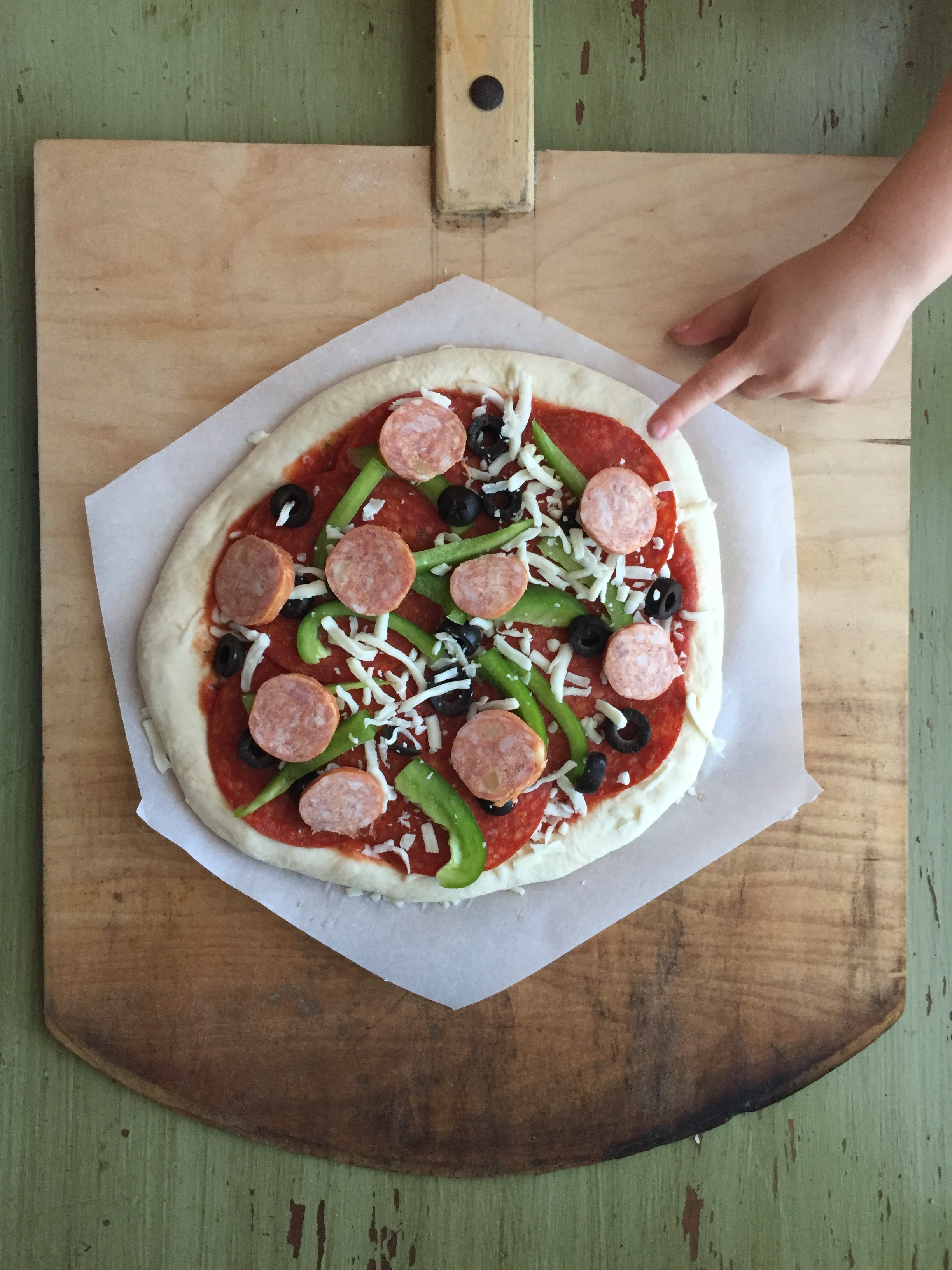  Do your final shape on parchment paper and add your toppings. Slide your peel under the pizza and its ready to bake! 