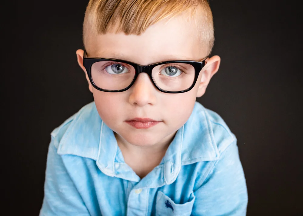 A media filter is often added to children’s glasses which reflects blue or purple in a photo. When possible, I remove it. If I am unable to remove it, I can send it off to a lab for removal. If you want glass glare removed from any pics, just add that picture to the cart and click on "glass glare removal." The cost is $2.50 per image.