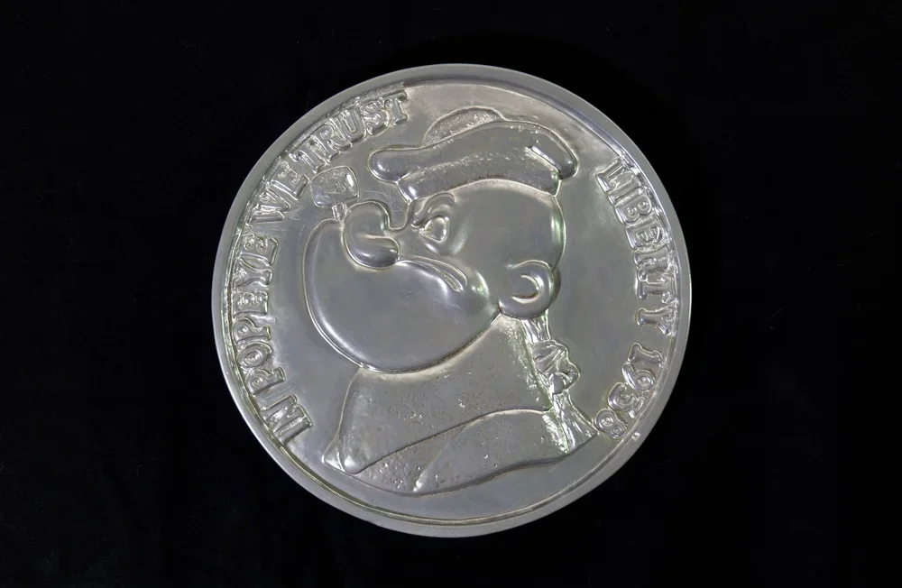    In Popeye We Trust    The Thomas Jefferson nickel this time, a companion piece from the "What if I chose the Presidents” giant coin series.  10.5 Diameter x 2”D; Ceramic &amp; enamel; wall-hanging  Part of The Sheldon Donig Collection, Los Angeles