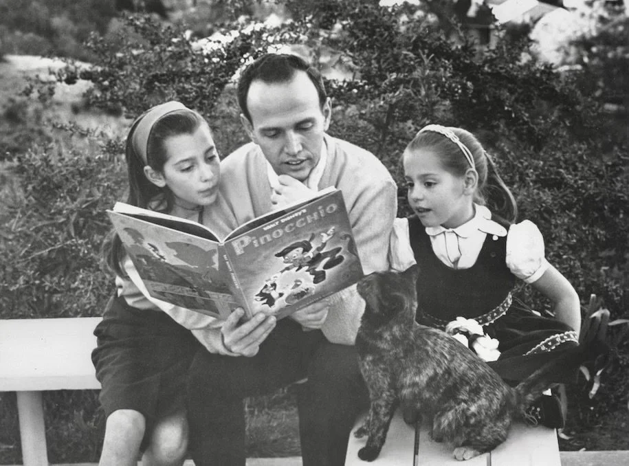 Roger reading to his daughters, Laura and Alice