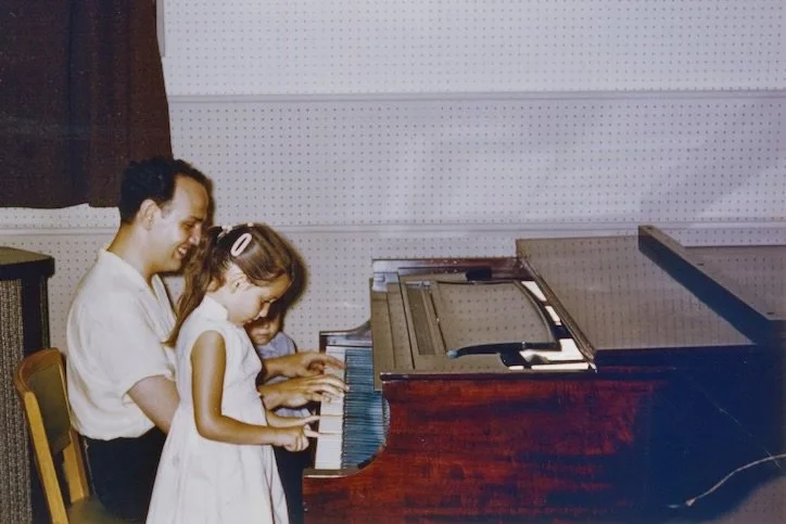 Roger with his young daughters at the piano