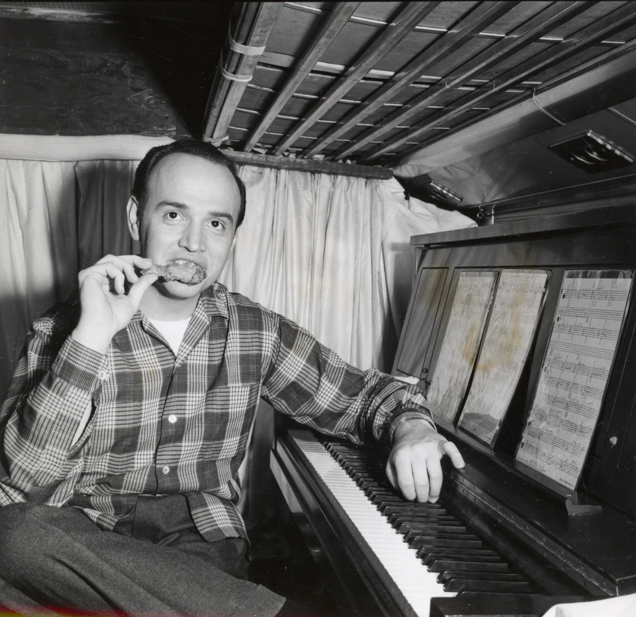 Roger has a snack by his piano aboard The Roger Williams Tour bus