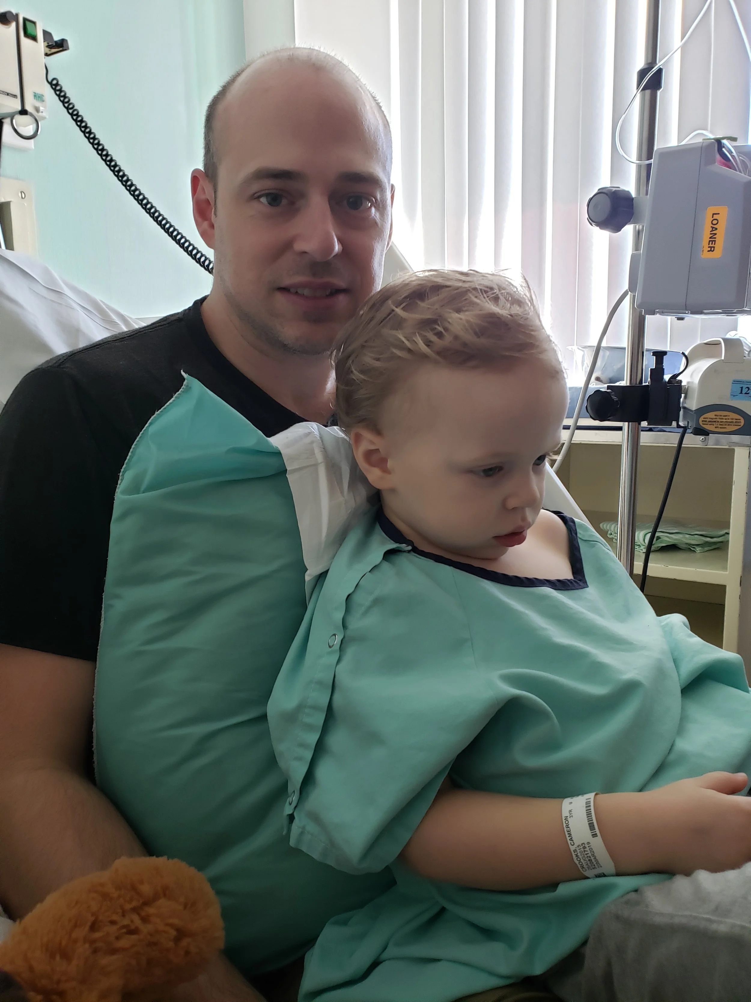Andy dutifully sitting under Cameron in his hospital bed while the pediatric unit investigated the source of his infection at Regina General Hospital.