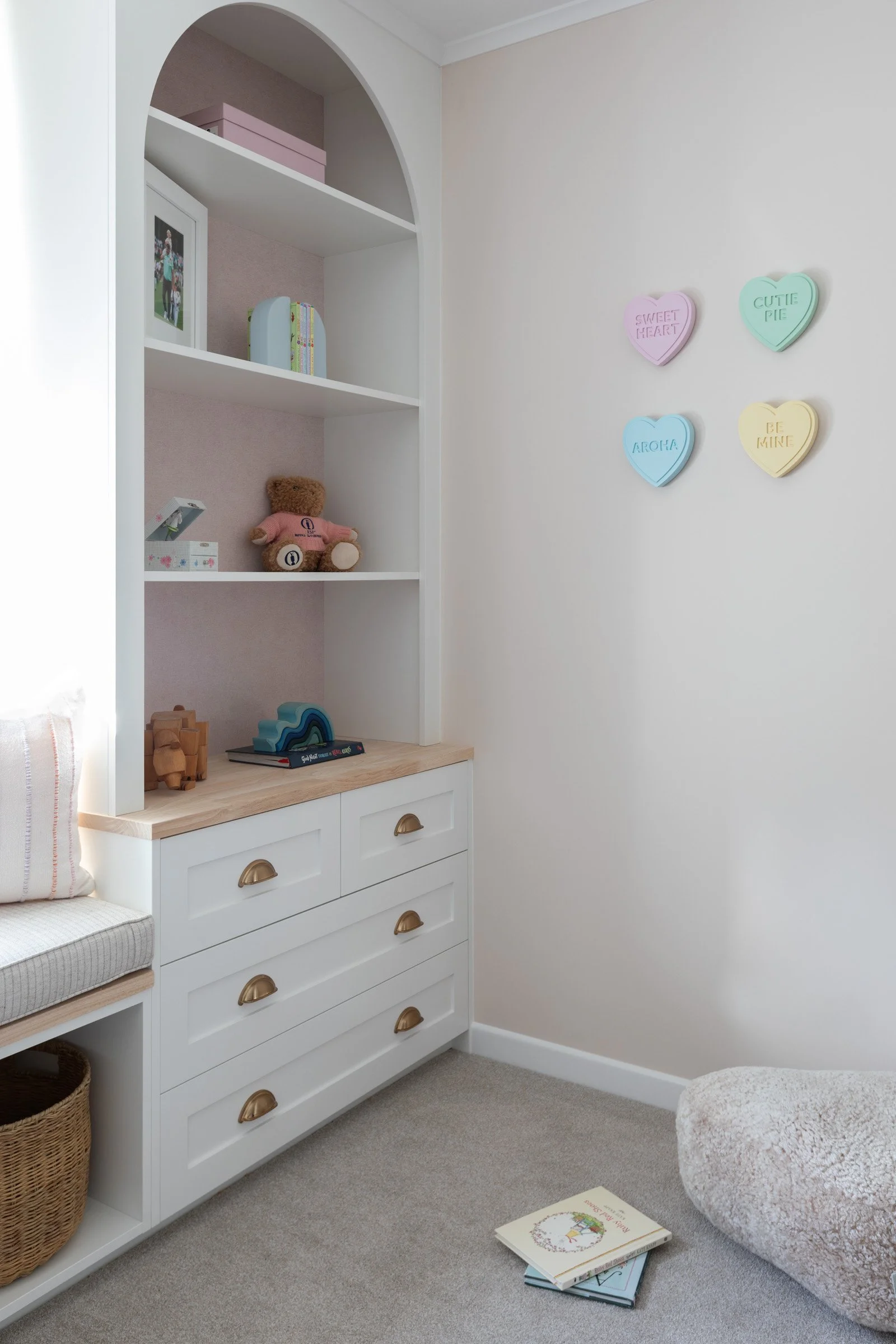 Girls bedroom with custom arched bookcase and windowseat