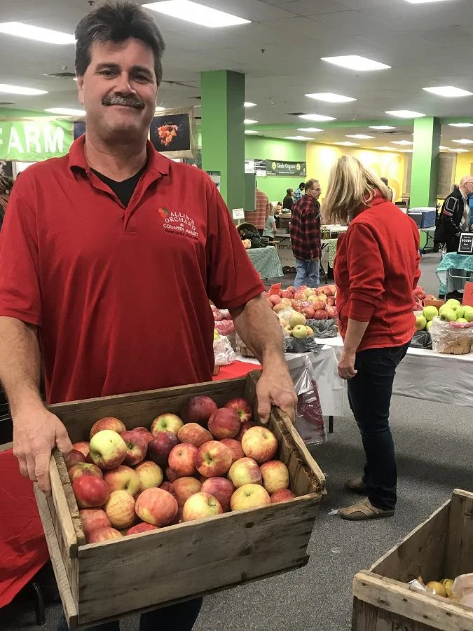Brian Allin hauls crates of apples from Allin’s Orchards to the winter location of the Peterborough Regional Farmers’ Market in Peterborough Square. (Photo: Barb Shaw / kawarthaNOW.com)