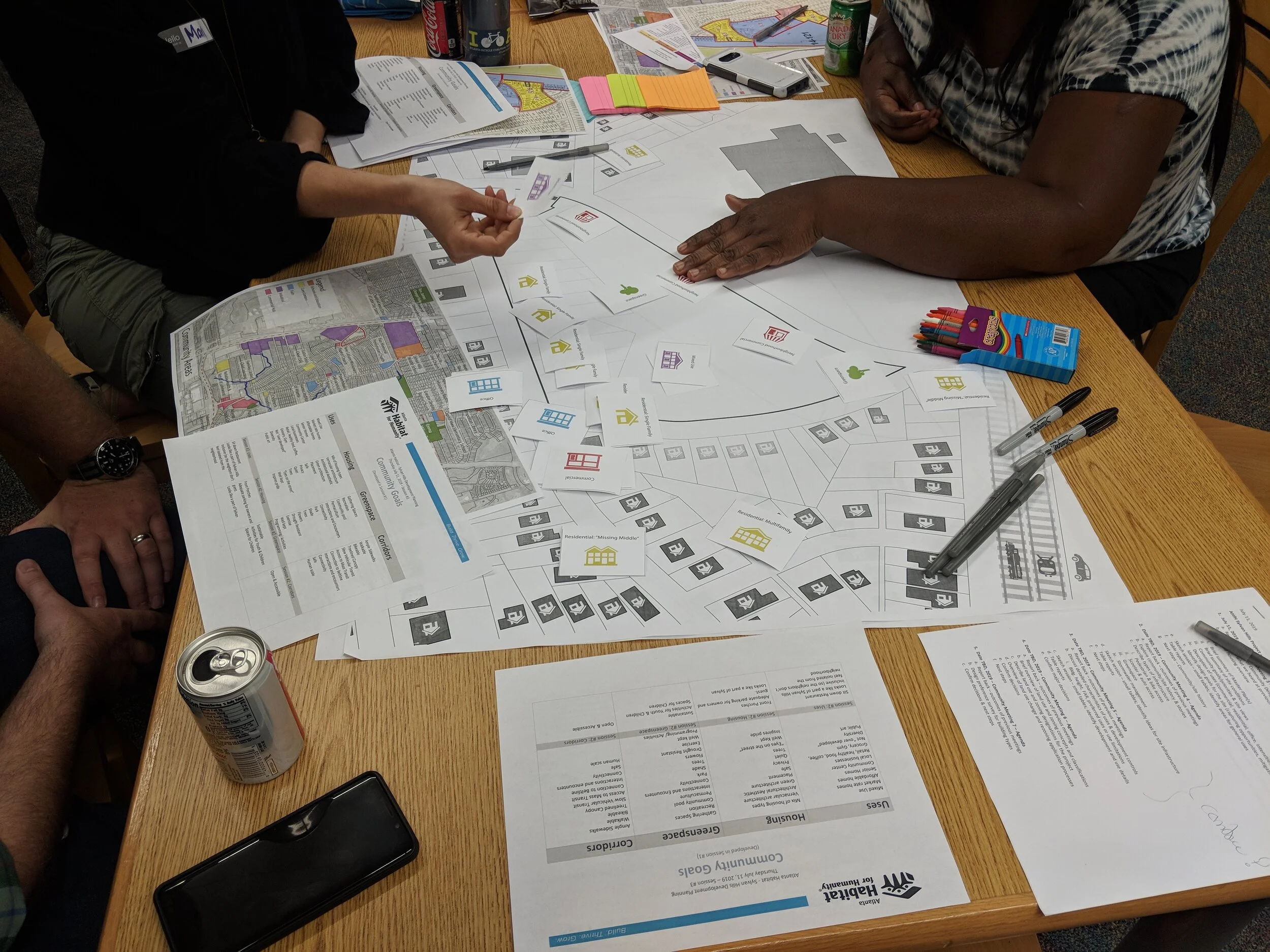  Creative activity where the community played with cards with different site uses and choose where or how they’d like to see them. This was held after a meeting on capacity building where the community learned site planning terms and other urban conc