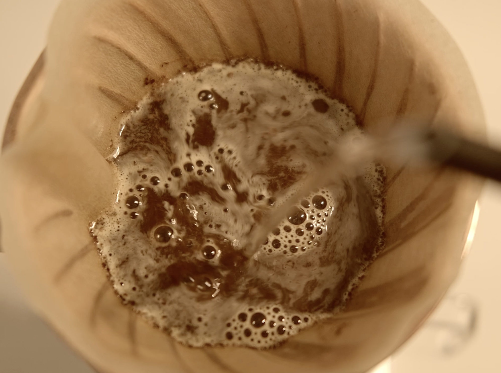 A view inside a coffee dripper with brewed coffee at the bottom.