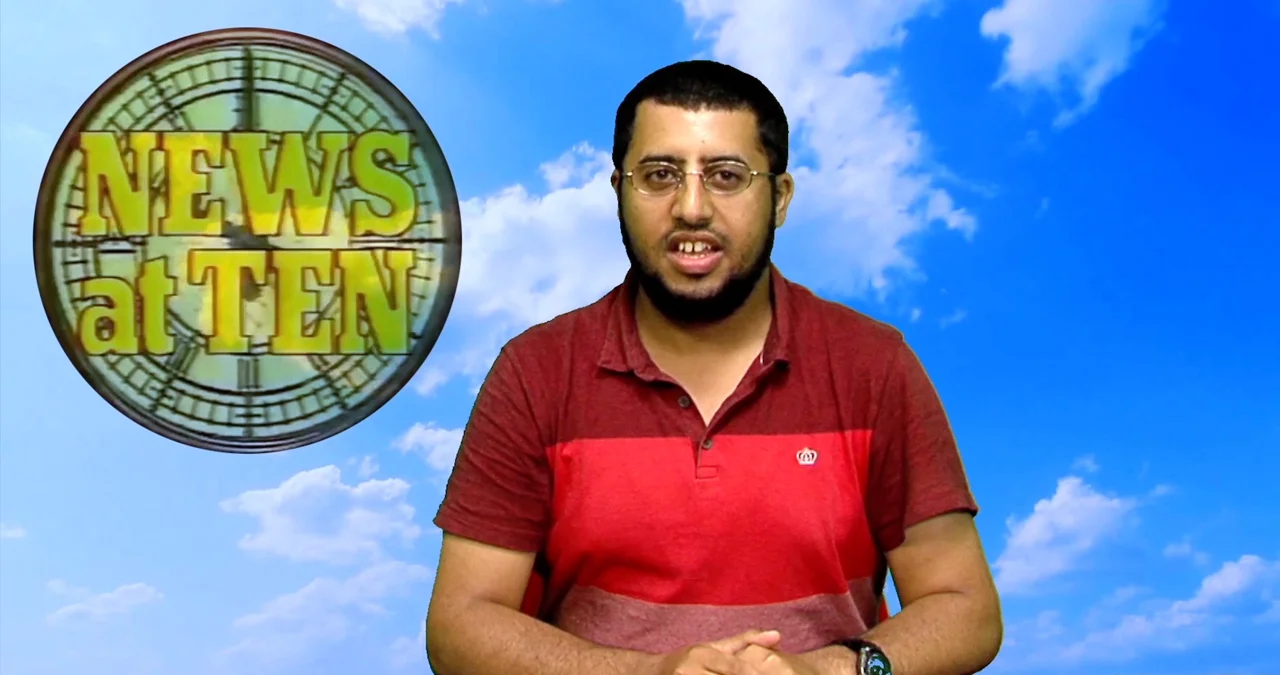 A newsreader sits in front of a blue sky and the News at Ten logo. A still from short film, Breaking News.