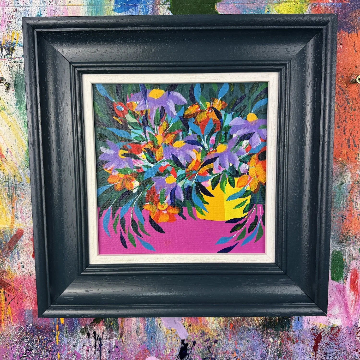 Bright colourful flowers in a yellow pot with a rich pink background, painting by Faye Bridgwater