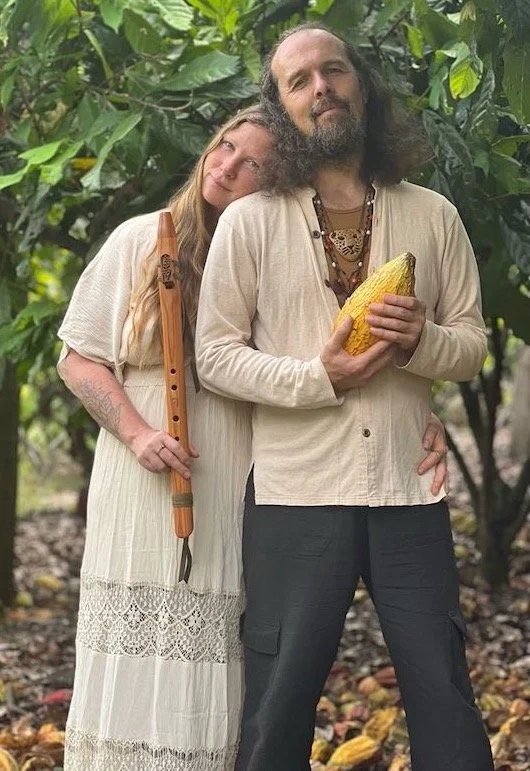 Portrait of Diana and Alku, Cacao Shamans, holding a flute and a cacao pod, in a cocoa forest of Northern Peru