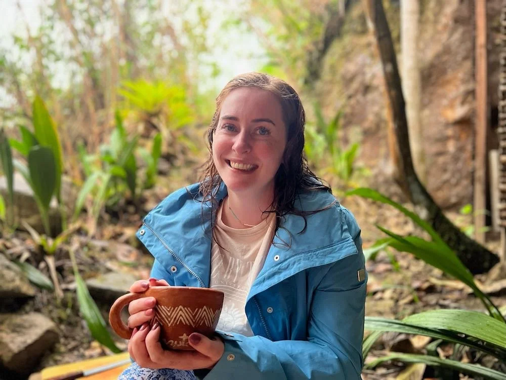 Smiling woman drinking pure Aynua ceremonial cacao in nature