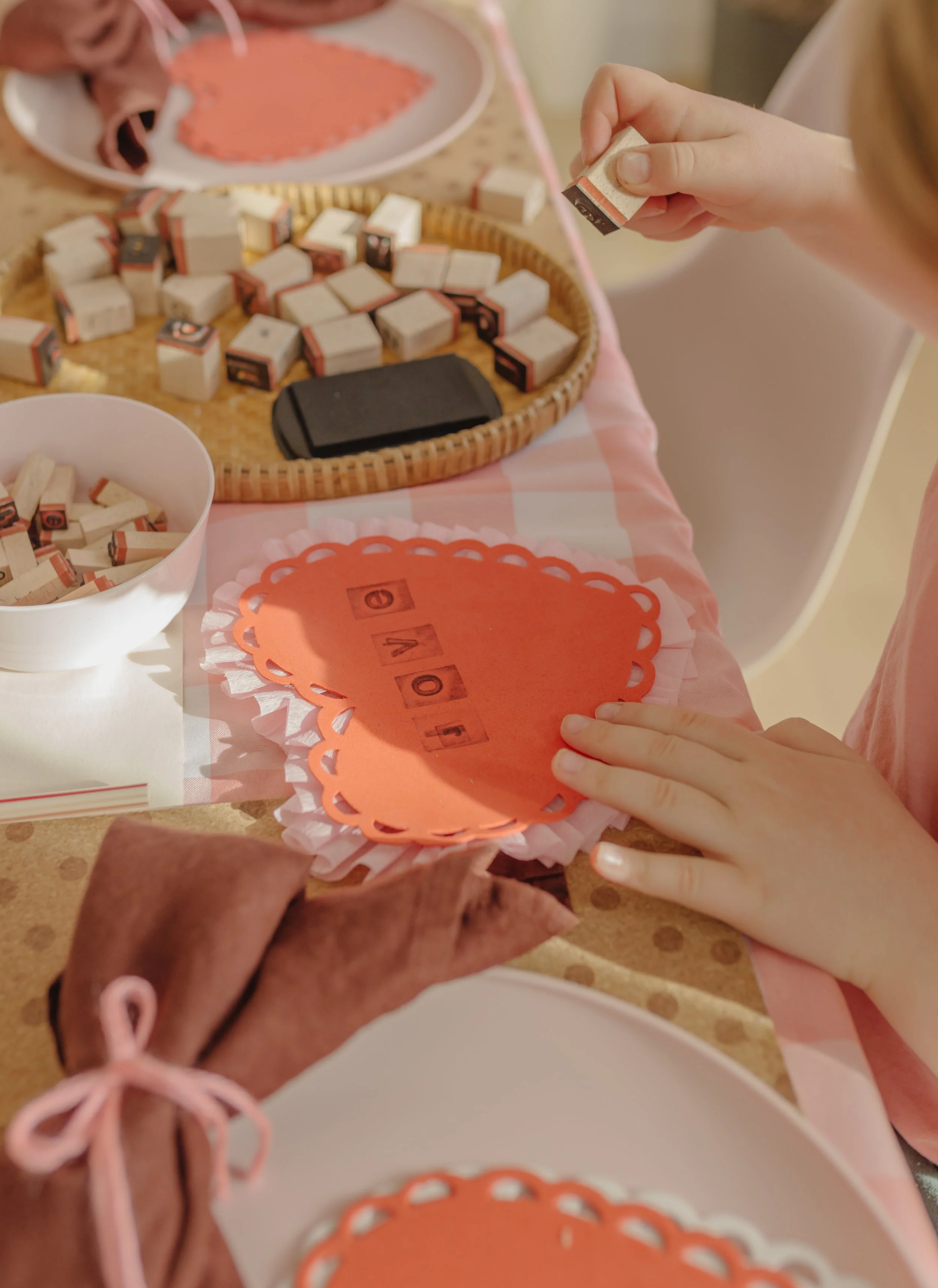 valentines day craft for kids using streamers and cardboard with a foam doily heart, adding stamped letters spelling "love" - valentines day craft ideas