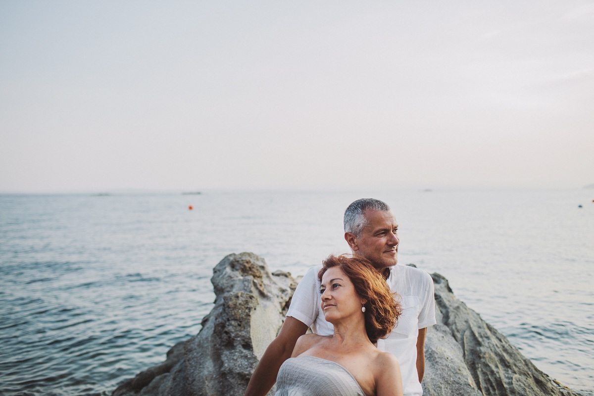 Couple sitting on a rock by the sea