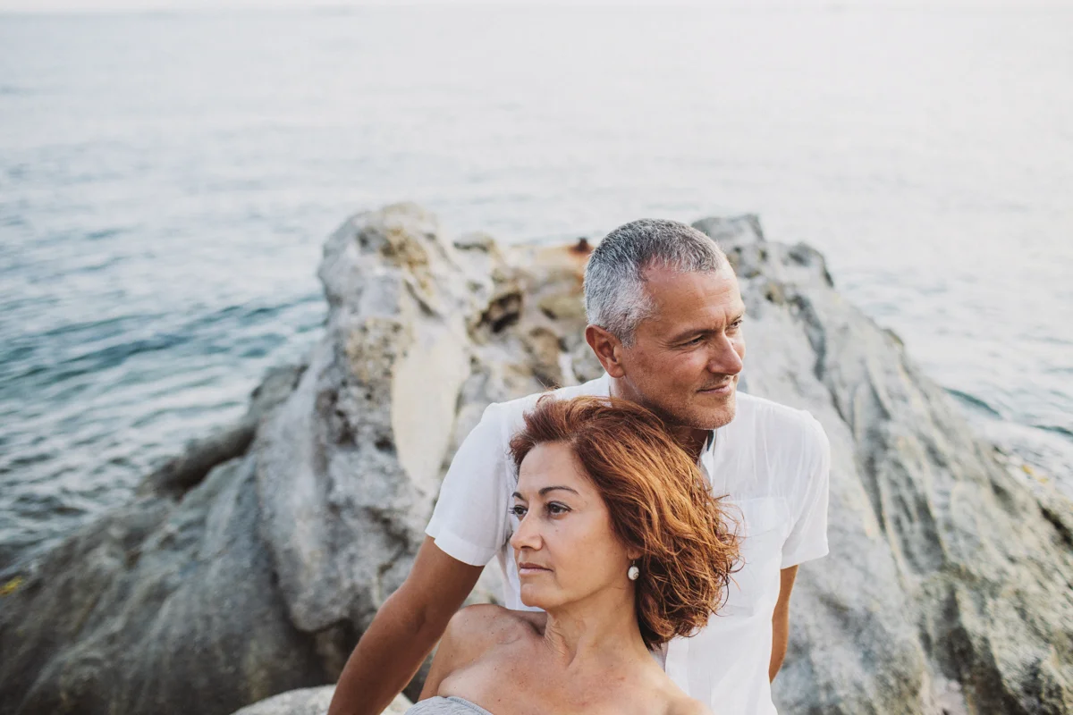 pareja tumbados en una roca en la playa