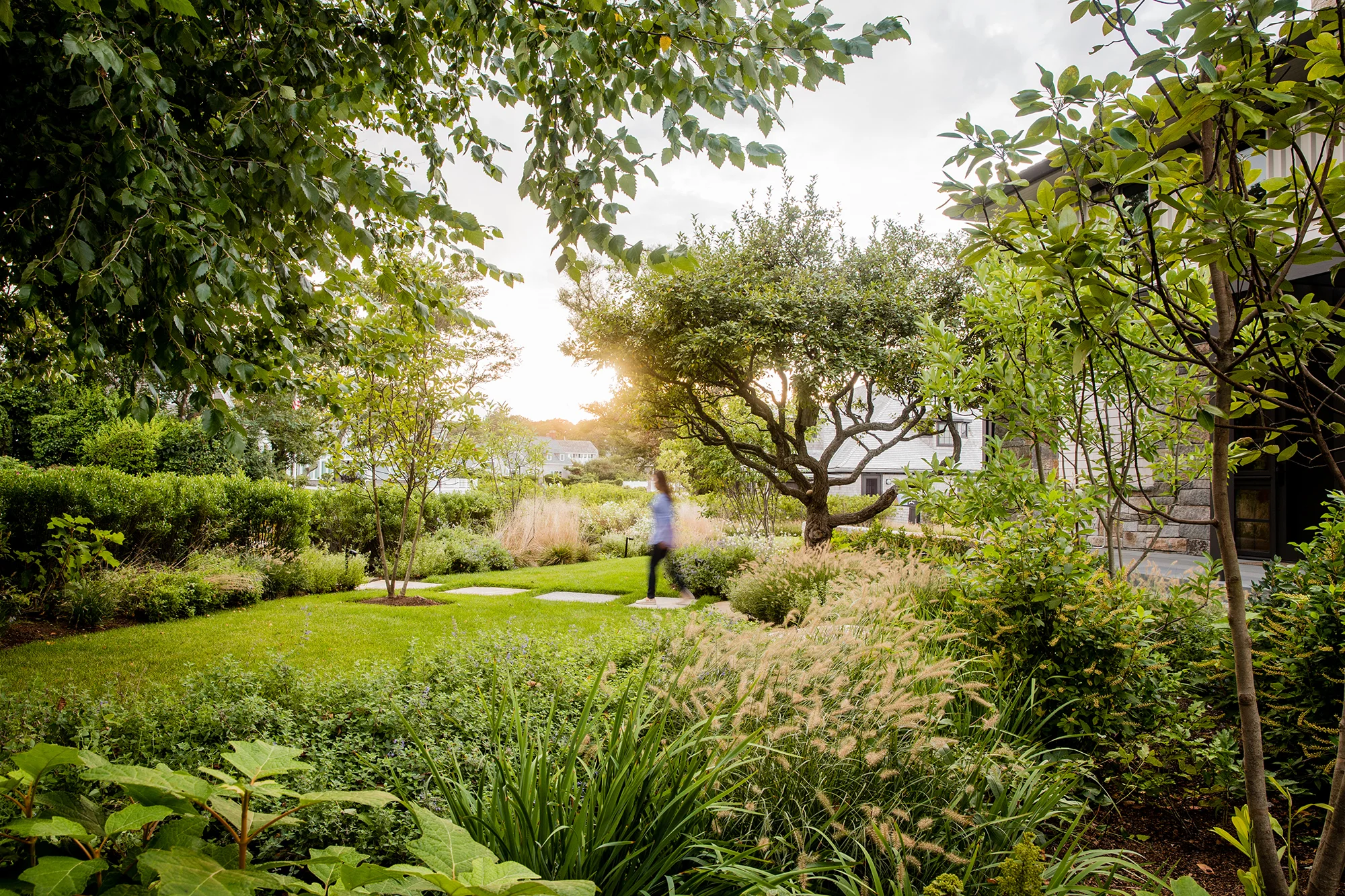 The client wanted to create a new summer residence for their family and for entertaining visitors. Though the site was small, the planned program for the site was ambitious, and included: a spa, outdoor dining area with pergola, fire pit, volley ball court, and outdoor showers. Walls of local stone provide a framework tying the disparate site elements together. The front entry garden serves as a threshold while providing privacy from the street and neighbors. The side yard serves as a shared lawn space inviting connections to the property to the west, also owned by the client. The top of the existing seawall was restored with a new blackened stainless steel guardrail added for safety, while native coastal meadow species add seasonal color and interest. Recognition Boston Society of Landscape Architects | Merit Award in Design 2019 Collaborators EPSTEIN JOSLIN Architects Photography Ngoc Doan STIMSON
