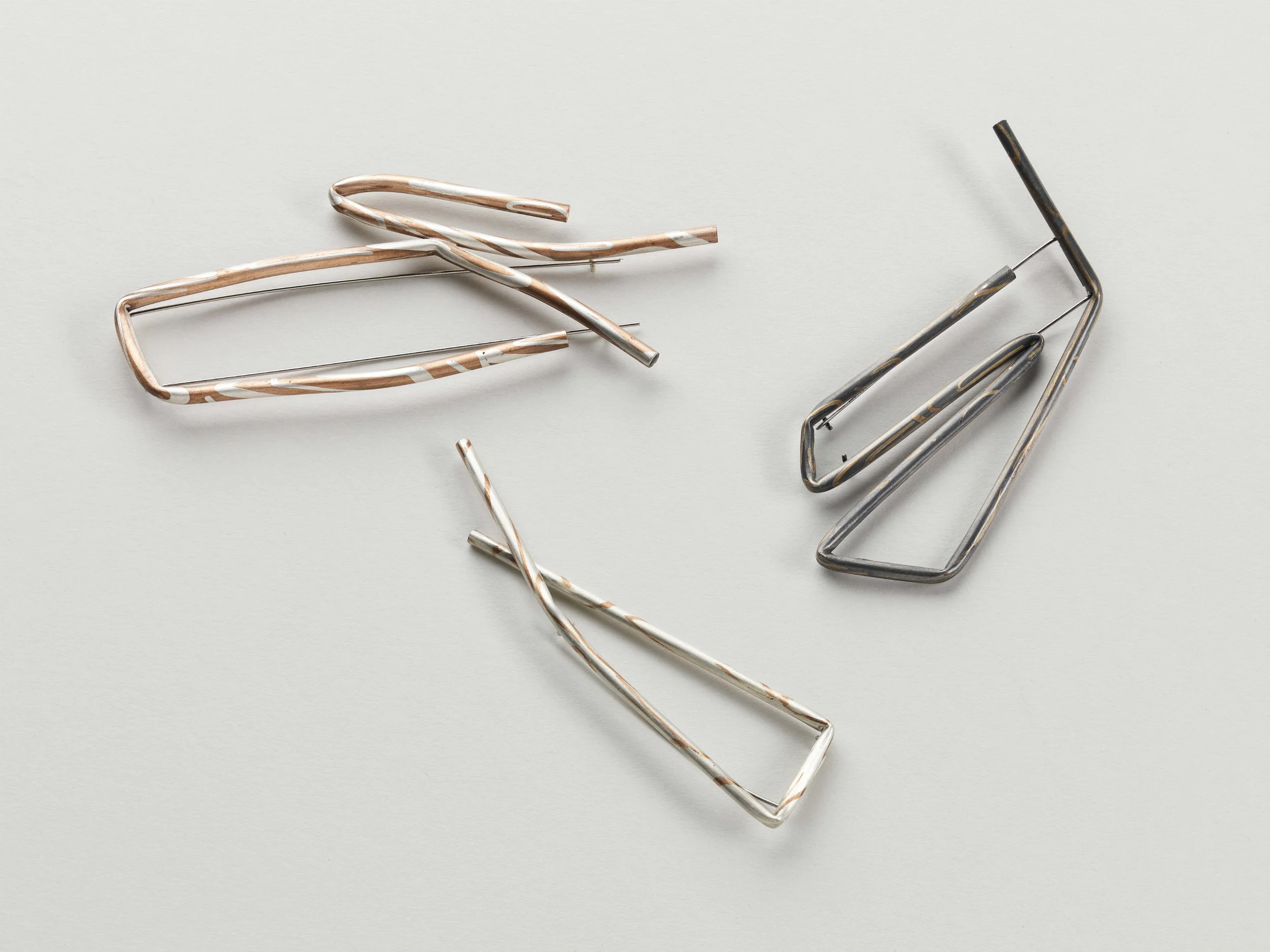 ‘Untitled’ Wire Inlay Brooch Series. Clockwise from top left; Copper, Sterling Silver and Smoky Quartz, Sterling Silver, 9 carat Gold and Sapphires, Sterling Silver, Copper and Smoky Quartz, Steel pin