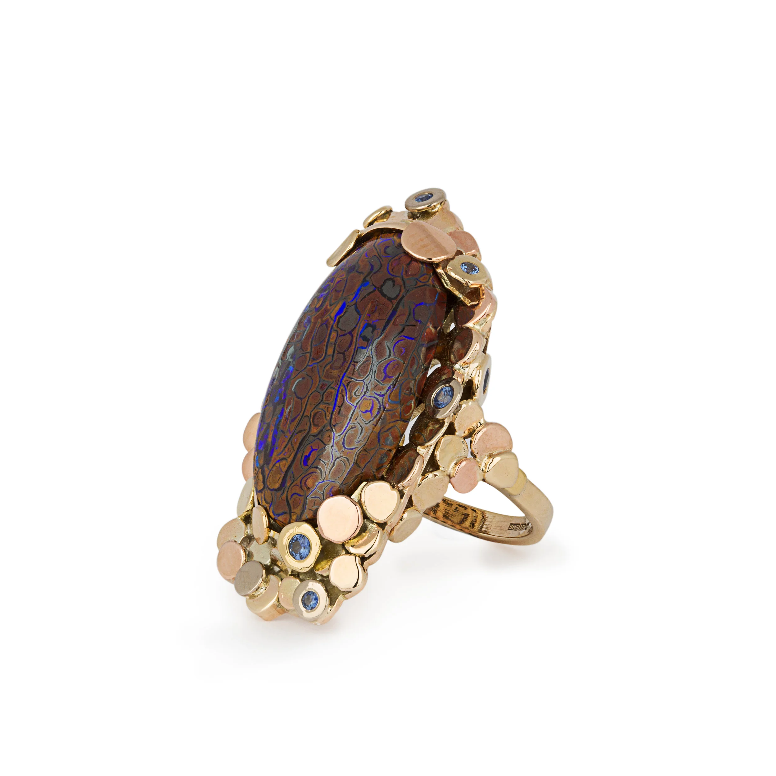 Recovered ship wrecked coins was the idea behind this ring a large koroite boulder opal with ceylon blue sapphires set around the design in mixed colours of gold 9ct and 18ct