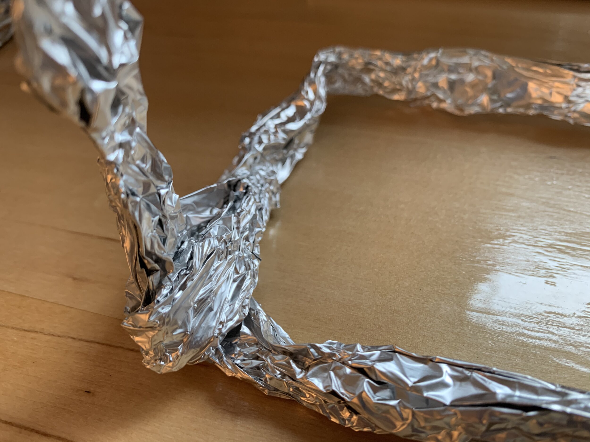 by hooking the excess of the first piece over the second