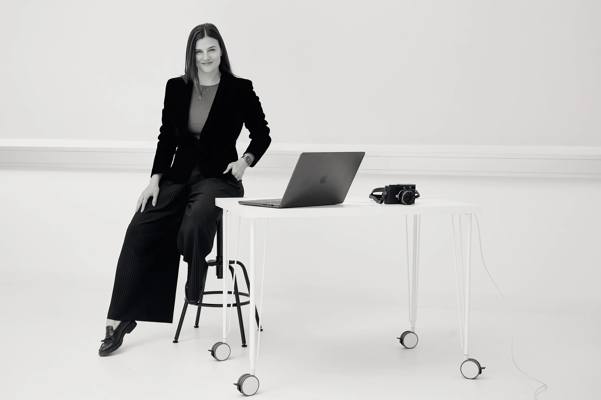 Florentina Olareanu of Golden Hour Pictures is sitting in her studio next to her laptop and camera.
