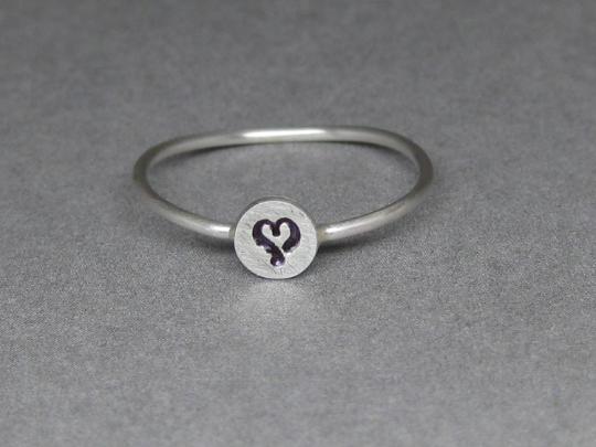 Stamped circle with heart in center