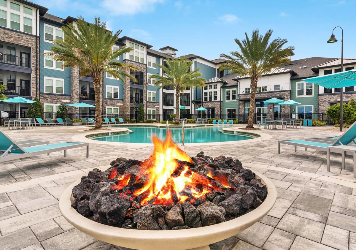 A fireplace next to a pool at apartment complex