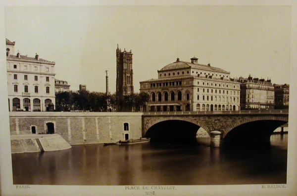 photo across parisian walled riverway with stone bridge