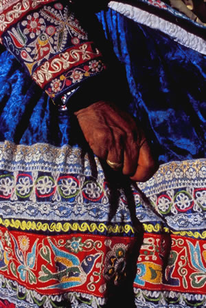 woman clutching skirt colorful fabric peru