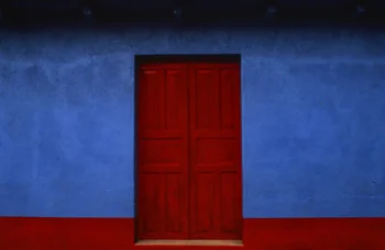 red wooden door adobe blue wall