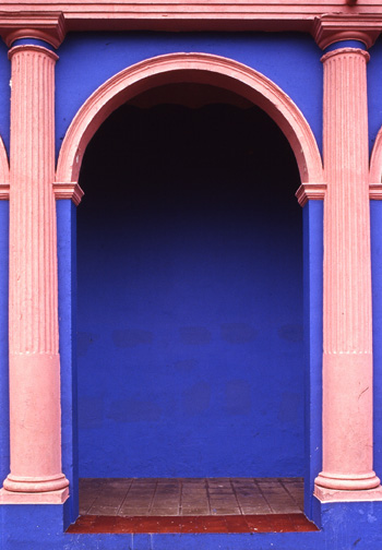 pink arches and greek columns over cobalt blue walls