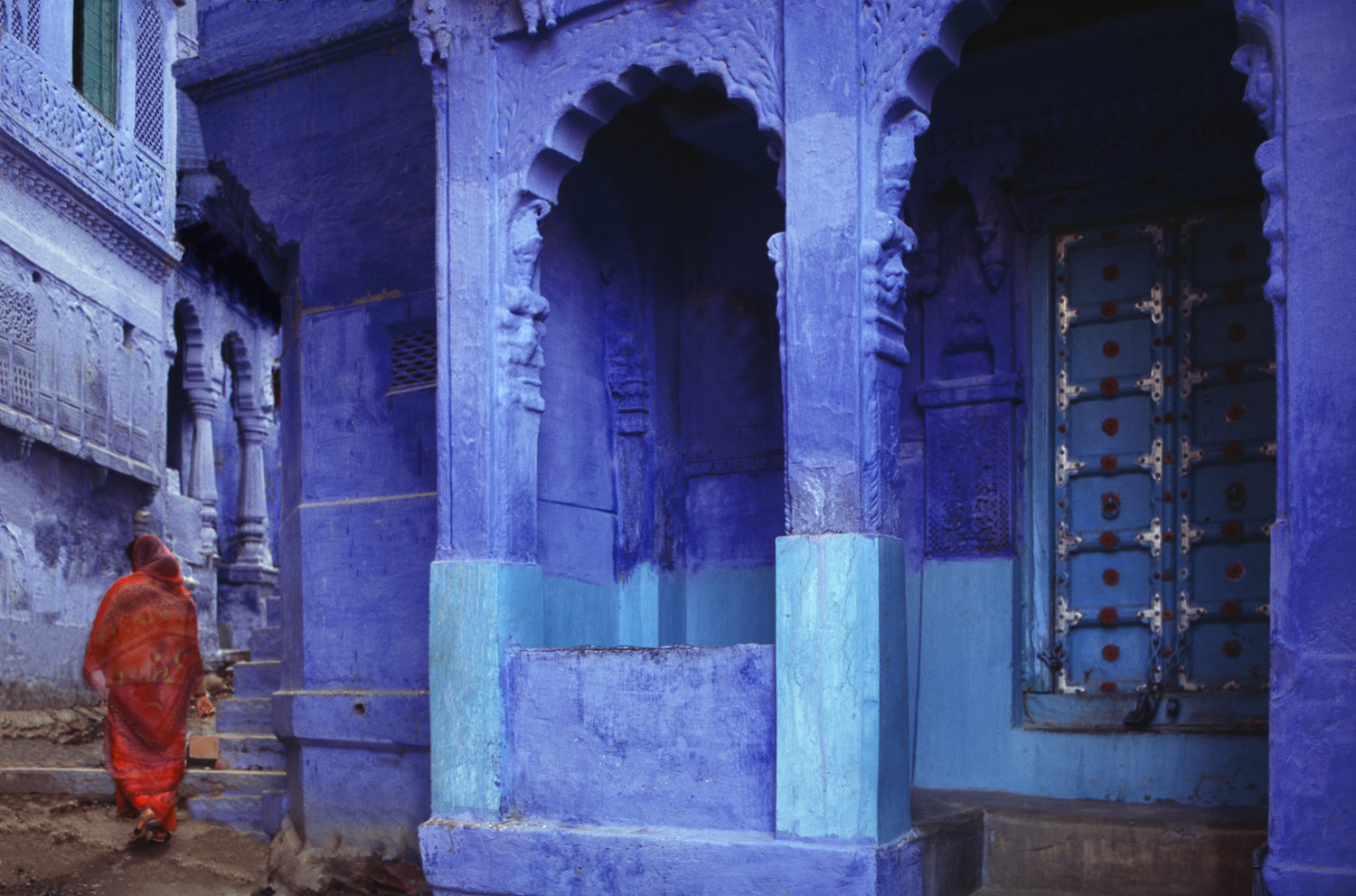 Blue temples with woman in orange walking up steps