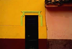 Black door with ornate gree moding orange wall