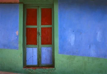 Colorful green red panneled window against green and blue wall