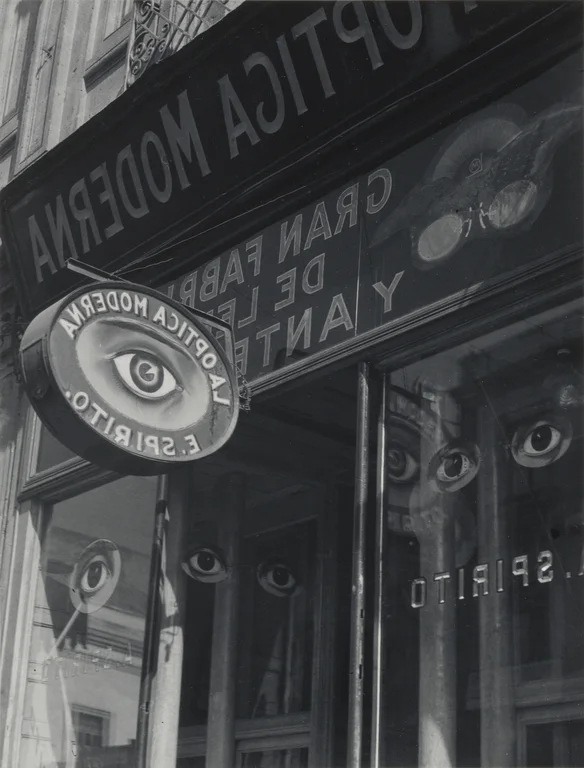 ornate painted storefront for optician with eyes painted on windows hanging sign