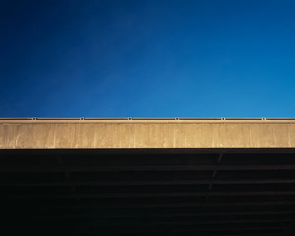 clear deep blue sky intersected by overpass