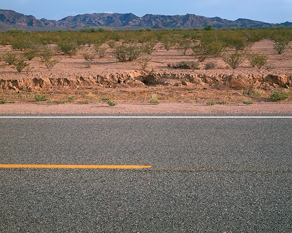 desert mountain landscape bisected by asphalt road