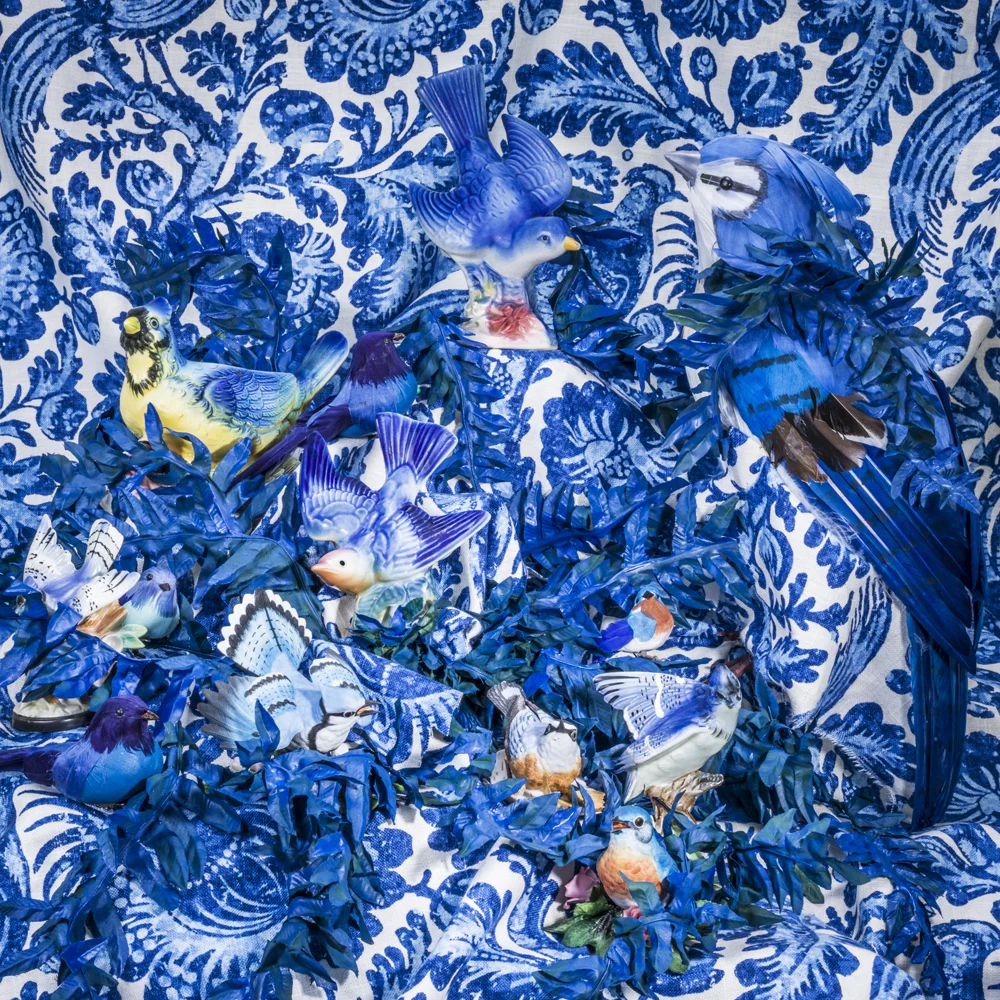 porcelain birds amongst blue china pattern fabric