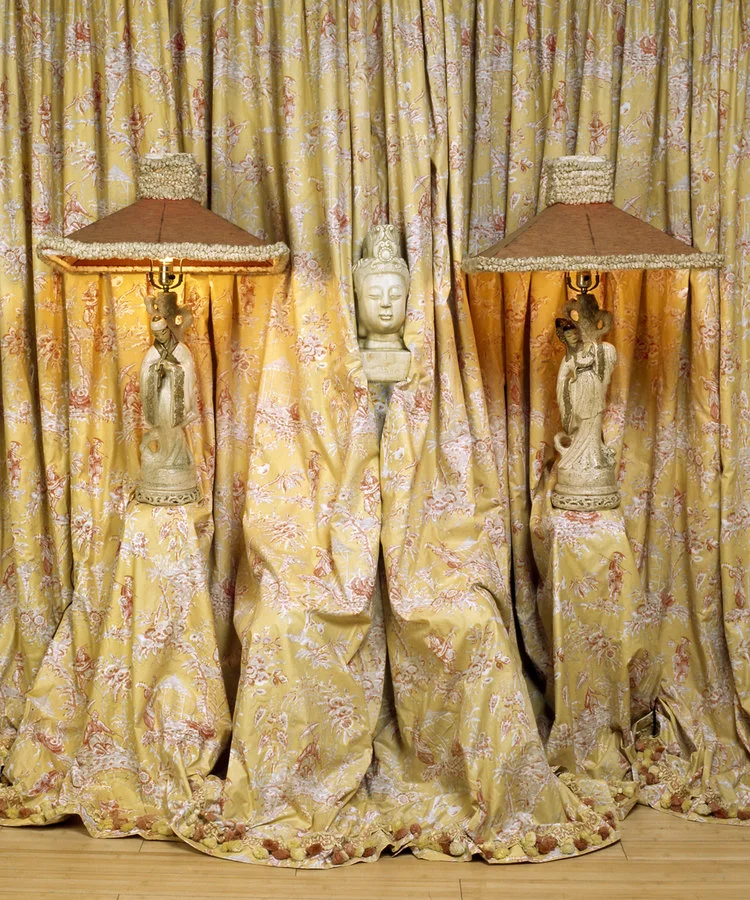 2 vintage ceramic lamps of asian women yellow curtains obscuring model holding Buddah head