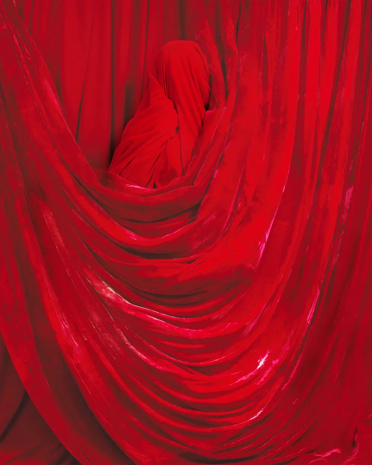 model wrapped in red velvet and red velvet curtains