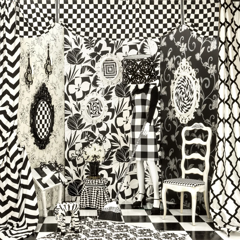 model sweeping an ornately draped black white room