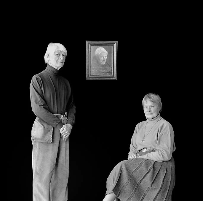 man standing picture on wall woman sitting