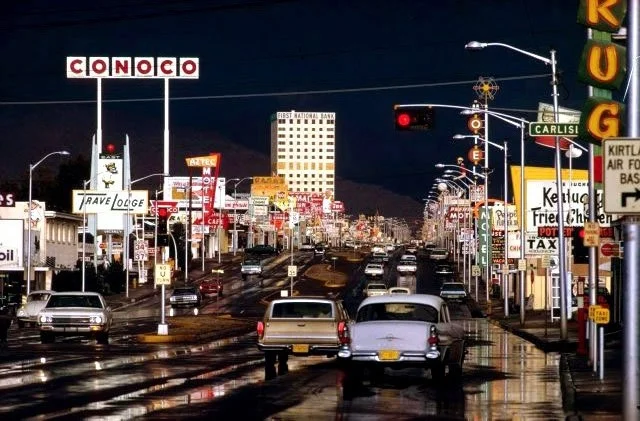 busy city street traffic after rain in 1969